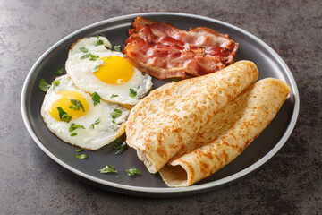 Delicious oatcakes served with egg and bacon close-up in a plate on the table. horizontal