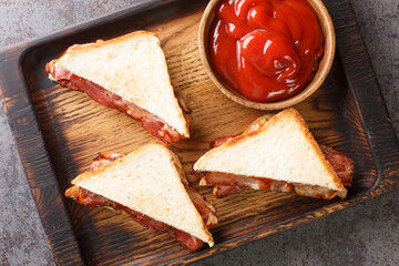 English Bacon Sandwich closeup in the wooden tray on the table. Horizontal top view from above