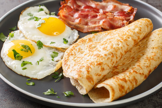 Staffordshire Oatcakes With Bacon And Fried Eggs Close-up In A Plate On The Table. Horizontal