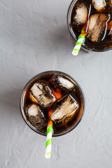 Cold Refreshing Dark Cola with Ice Cubes, Straws on a gray background, top view. Flat lay,...