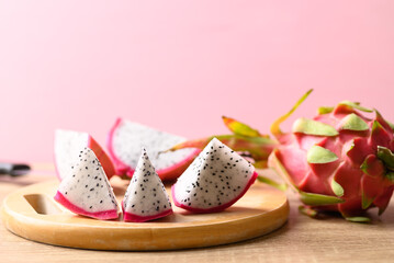 Obraz na płótnie Canvas Sliced dragon fruit or pitaya on wooden with pink background, Tropical fruit