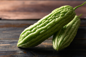 Bitter melon or bitter gourd on wooden background, Organic vegetables from local market in Thailand