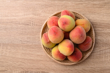 Peach fruit in basket on wooden background, Table top view