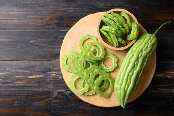 Sliced bitter melon or bitter gourd on wooden board prepare for cooking, Table top view