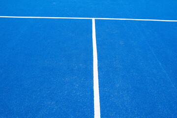 partial view of a blue turf paddle tennis court