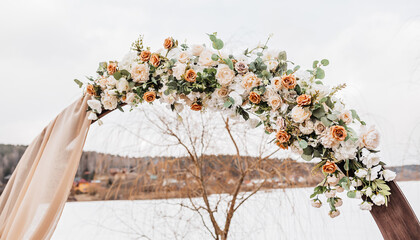 Wedding round arch with flowers and fabric in spring or winter. The place of the bride and groom for the ceremony in nature - obrazy, fototapety, plakaty