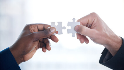 Problems are better solved together. Cropped shot of two unrecognizable businesspeople completing a...