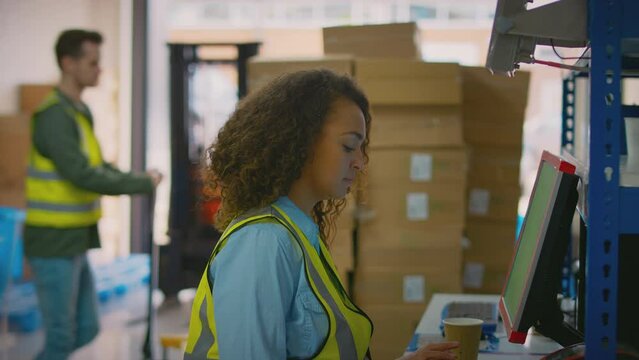 Male And Female Workers Using Computer Terminals And Moving Boxes In Distribution Warehouse - Shot In Slow Motion