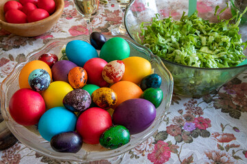 Obraz na płótnie Canvas Table ready to celebrate Easter with traditional colorful eggs on a plate.