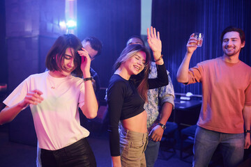 Dancing together. Group of friends having fun in the night club