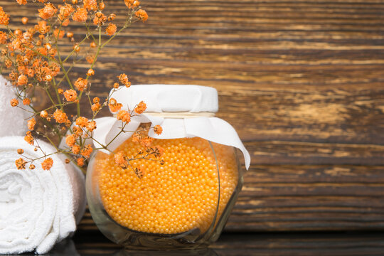 jar with orange bath salt on wooden background