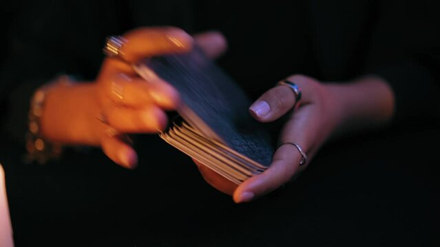 Close-up oracle hands shuffling tarot cards, magic ritual, witchcraft business