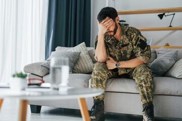 Post traumatic stress disorder. Soldier in uniform sitting indoors