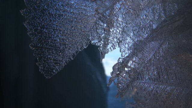 Beautiful crystal icicles, blue sharp ice and snowflakes inside frozen cave 