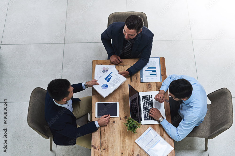 Poster running through the numbers together. high angle shot of three colleagues having a business meeting 