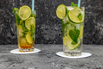 Fototapeta premium Mojito cocktail drink with lime and mint on dark background with copy space