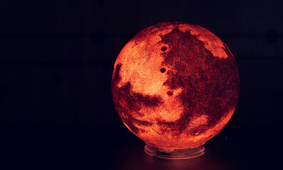 Red planet model close up on black background. Space concept