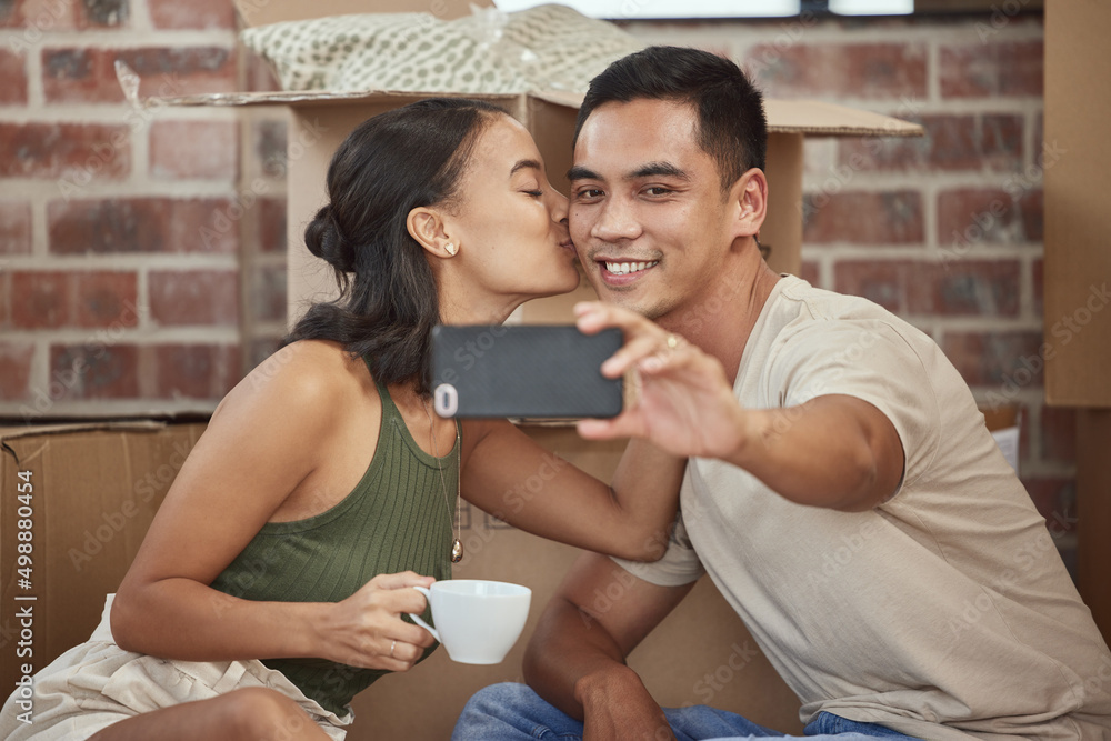 Poster this home is filled with love. shot of a young couple taking a selfie while sitting in their new hom