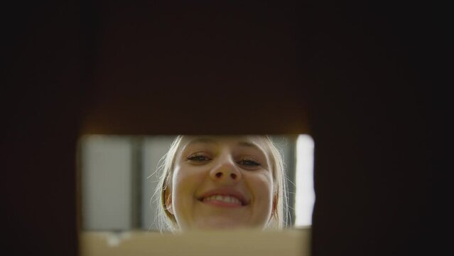 Point of view shot of female intern in distribution warehouse closing and sealing box - shot in slow motion