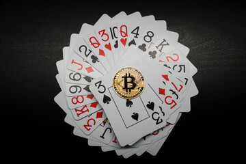 Bitcoin coin on a deck of playing cards. Bitcoin casino game. Cryptocurrency excitement. Bet on bitcoins.