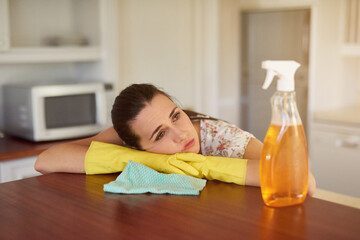 Theres just too many chores to do. Shot of a tired looking young woman leaning on a kitchen...