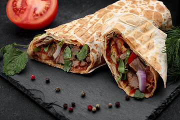 Shawarma with veal, with tomato in the background