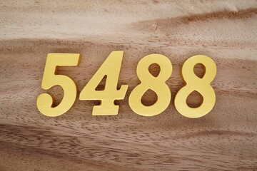 Golden Arabic numerals on a real brown and white wooden floor number 5488