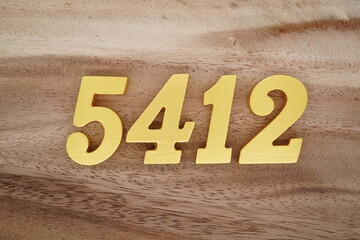 Golden Arabic numerals on a real brown and white wooden floor number 5412