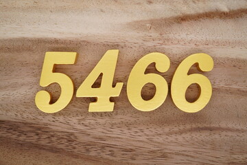 Golden Arabic numerals on a real brown and white wooden floor number 5466