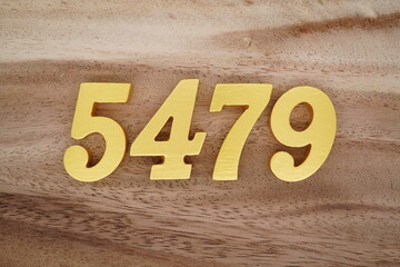 Golden Arabic numerals on a real brown and white wooden floor number 5479