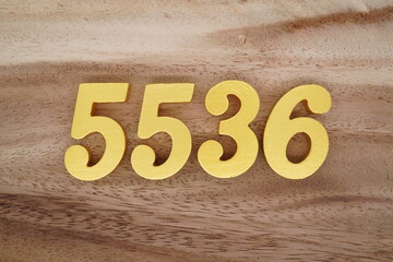 Golden Arabic numerals on a real brown and white wooden floor number 5536