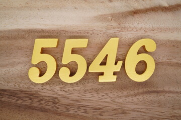 Golden Arabic numerals on a real brown and white wooden floor number 5546