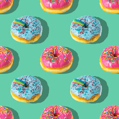 Repeating pattern of pink and blue rainbow donuts on a blue background