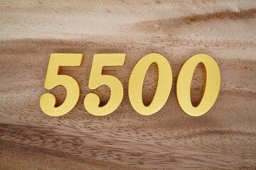 Golden Arabic numerals on a real brown and white wooden floor number 5500