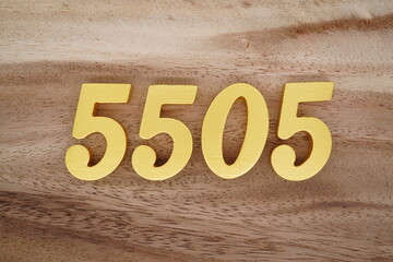 Golden Arabic numerals on a real brown and white wooden floor number 5505