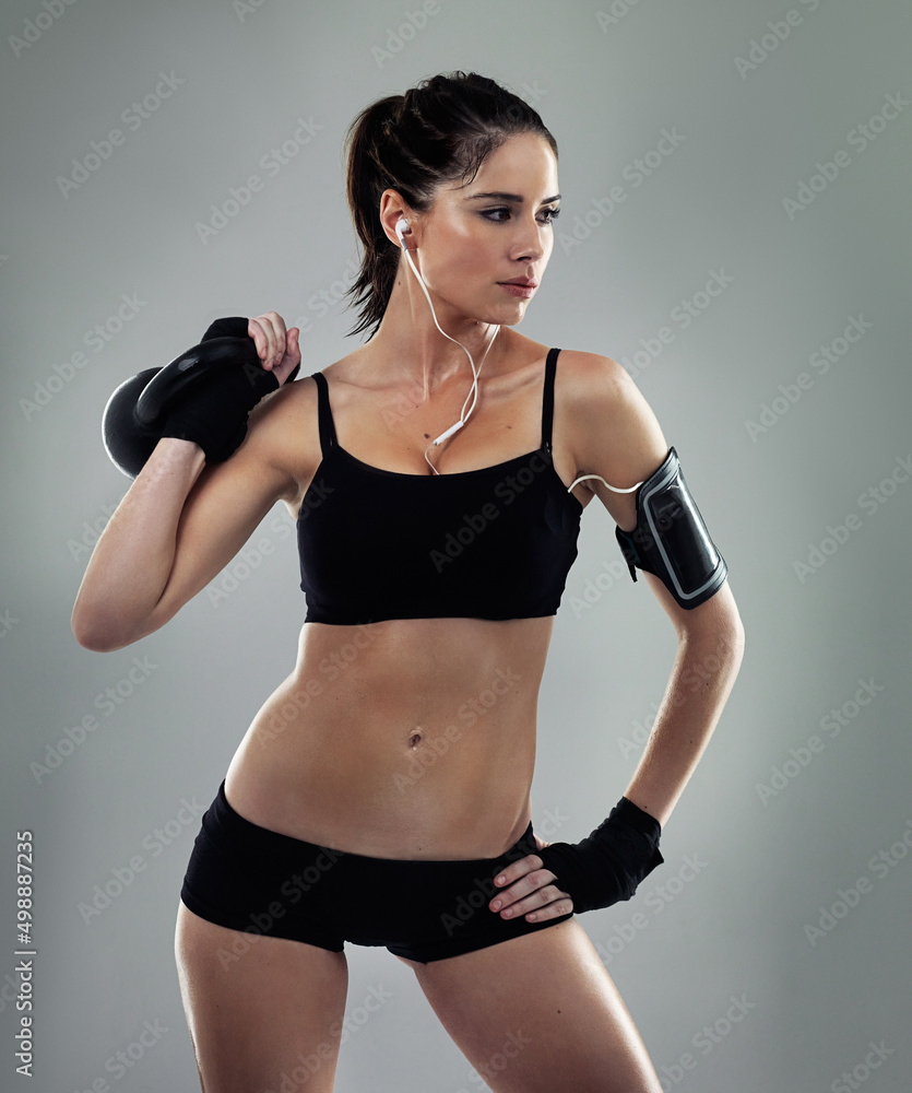 Poster Solid workouts build solid bodies. Studio shot of a sporty young woman against a gray background.