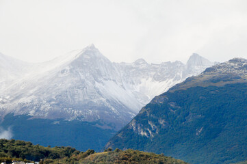 Mountain peaks covered with snow and hills with grass and vegetation
