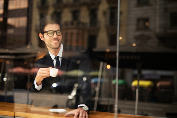 Handsome businessman enjoy in fresh coffee. Young man in suit drinking coffee in cafe..