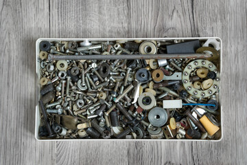 Box of screws on wood background
