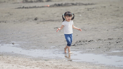 Fototapeta na wymiar 磯遊びする3歳の子供（レジャー・海）