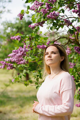 woman in the garden with blooming lilac