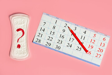 Woman menstrual calendar, control of the regular cycle, pencil and sanitary pad napkin with a question.