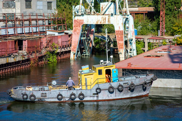 Fototapeta na wymiar a river tug pulling a floating barge from their dry dock