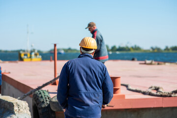dock workers on a river barge in the port