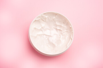 open white plastic box with body cream on pink background