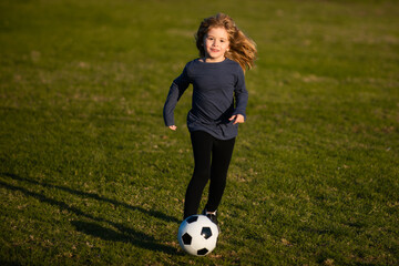 Soccer kid. Kids play football on summer stadium field. Little child boy kicking ball. Cute boy kicking soccer ball.
