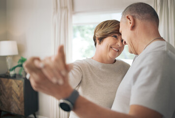 Being in your arms is my favourite place. Shot of a mature couple slow dancing in their lounge.