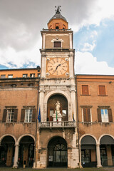 Fototapeta na wymiar the municipal tower located at Piazza Grande in Modena, Italy. In the center of the tower there is an ancient clock.