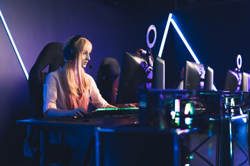 blonde European girl playing in gaming tournament medium full shot indoors studio shot eSport concept. High quality photo