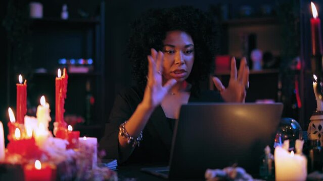 Mysterious witch consulting client online, telling fortune, treating by hypnosis